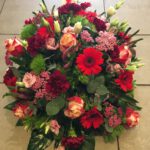 rouwwerk met rode en roze bloemen